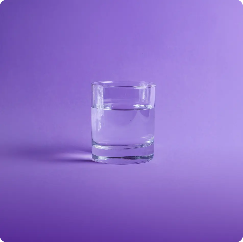 Glass of water half full to represent watery feeling eyes causes by tear evaporation